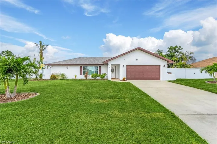 White stucco exterior with a brown garage door, dark brown roof, and a concrete driveway