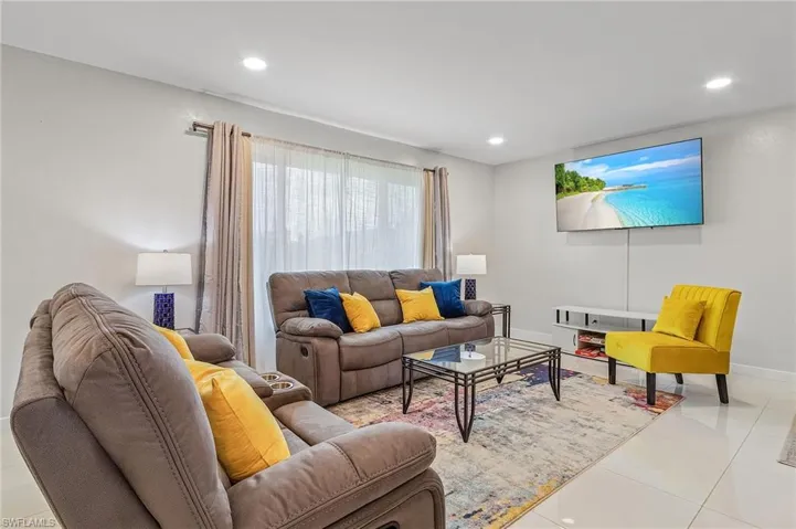 Bright living area featuring recessed lighting and tile flooring
