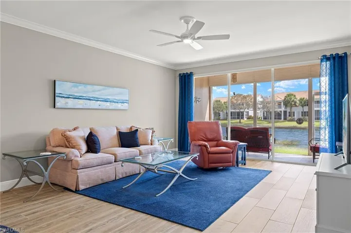 Living room featuring light hardwood / wood-style flooring, ornamental molding, and ceiling fan
