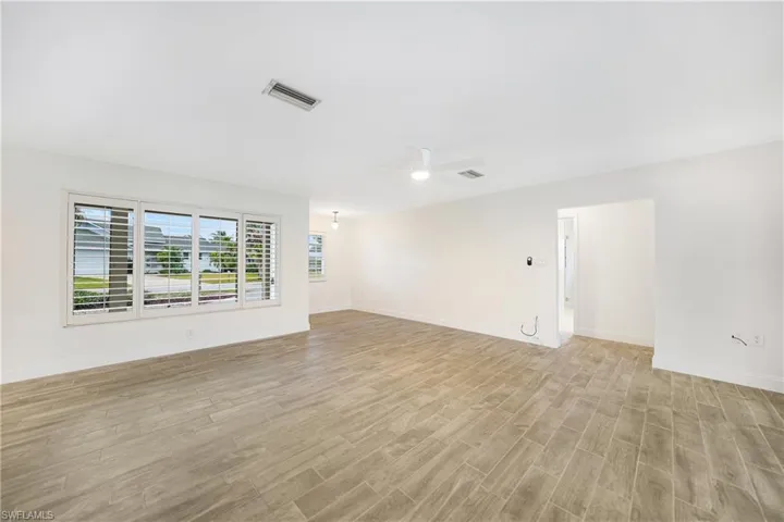 Empty room with ceiling fan and light wood-type flooring