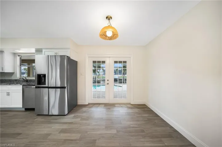 Kitchen with french doors, white cabinetry, stainless steel appliances, and plenty of natural light