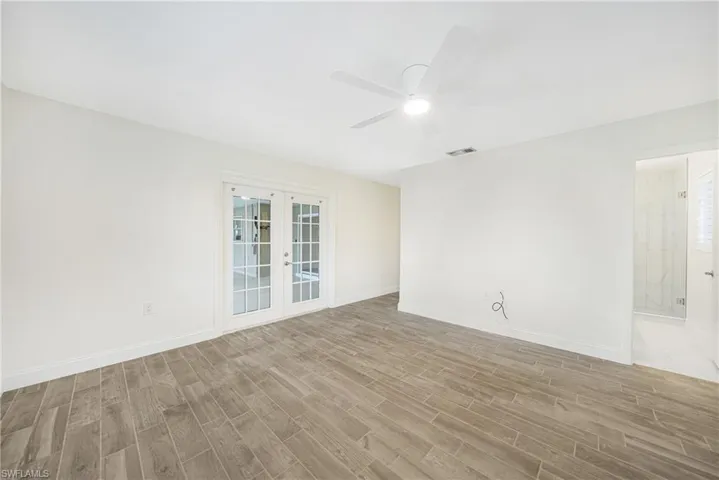 Empty room featuring light hardwood / wood-style flooring, ceiling fan, and french doors