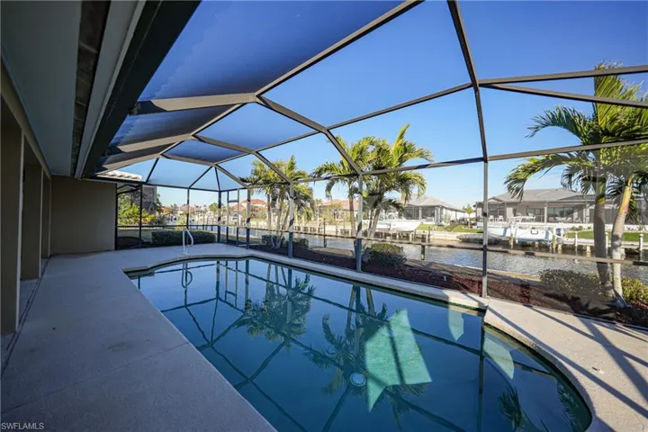 View of swimming pool featuring a water view, a lanai, and a patio area