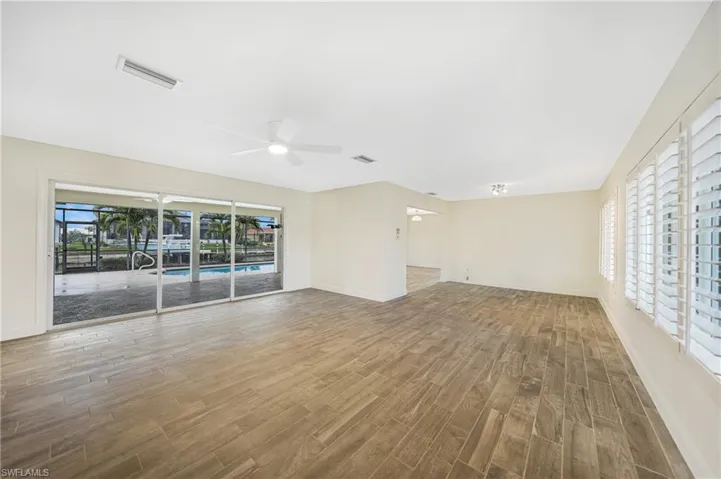 Unfurnished living room featuring ceiling fan and hardwood / wood-style floors