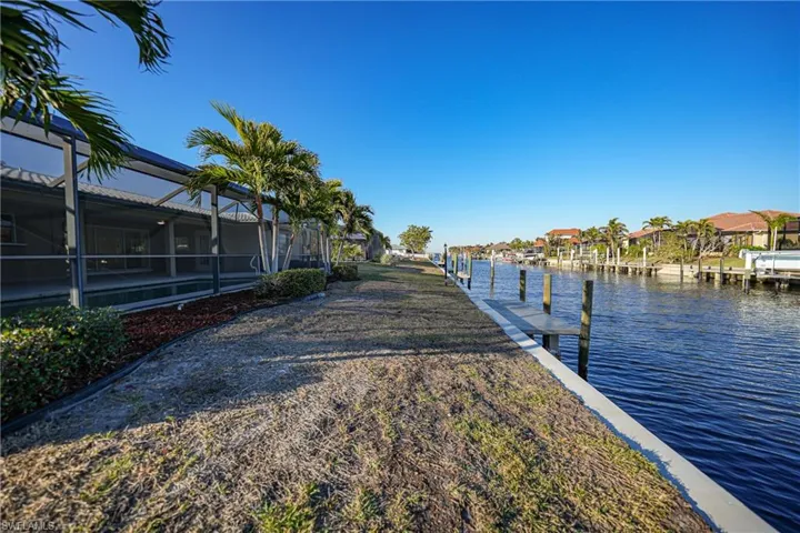 Dock area with a water view and glass enclosure