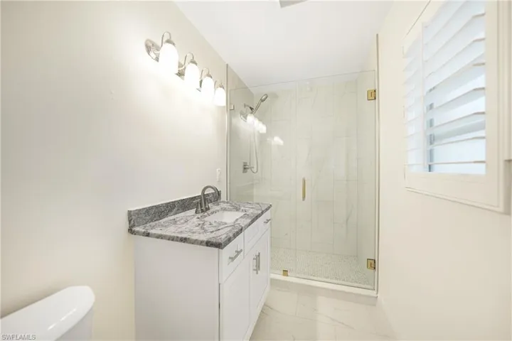 Bathroom with walk in shower, vanity, and toilet