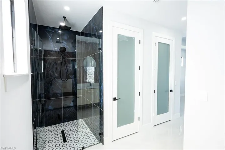 Full bathroom featuring a shower stall, baseboards, and recessed lighting