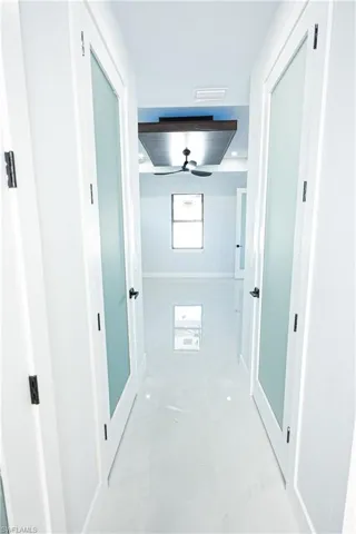 Corridor featuring marble finish floor, baseboards, and visible vents