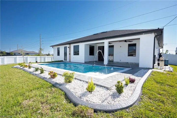 View of swimming pool with a fenced in pool, a patio, a fenced backyard, ceiling fan, and a lawn