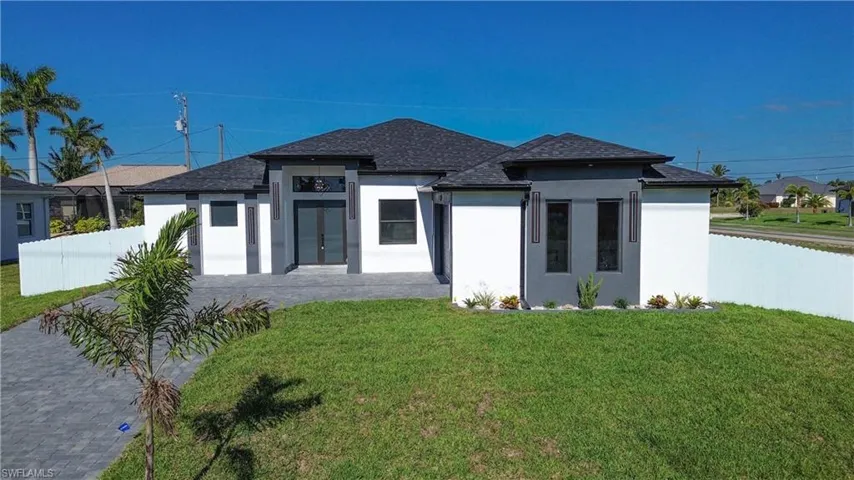 View of front of house with stucco siding, french doors, a front lawn, fence, and a shingled roof