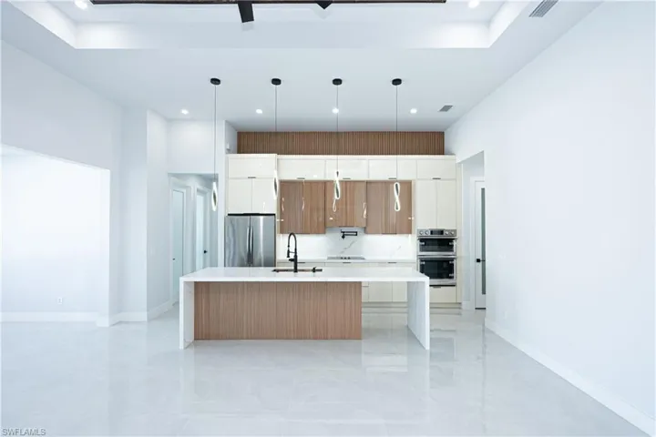 Kitchen with stainless steel appliances, white cabinets, modern cabinets, and light countertops