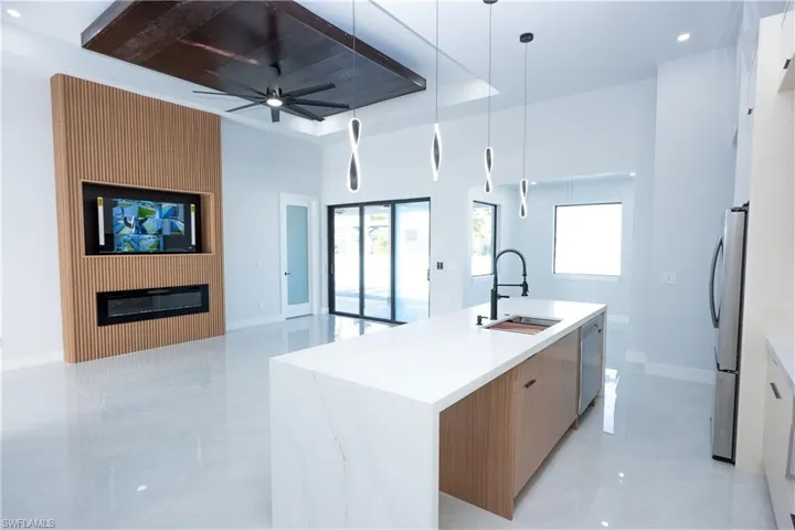 Kitchen with ceiling fan, modern cabinets, appliances with stainless steel finishes, a sink, and open floor plan