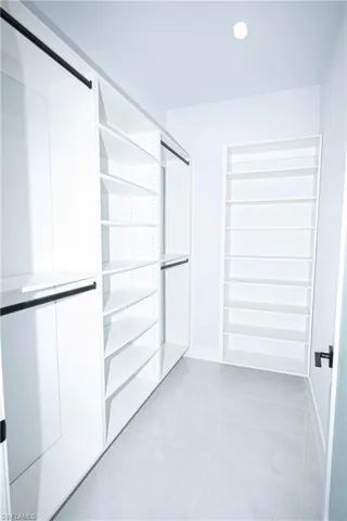 Spacious closet featuring marble finish floor