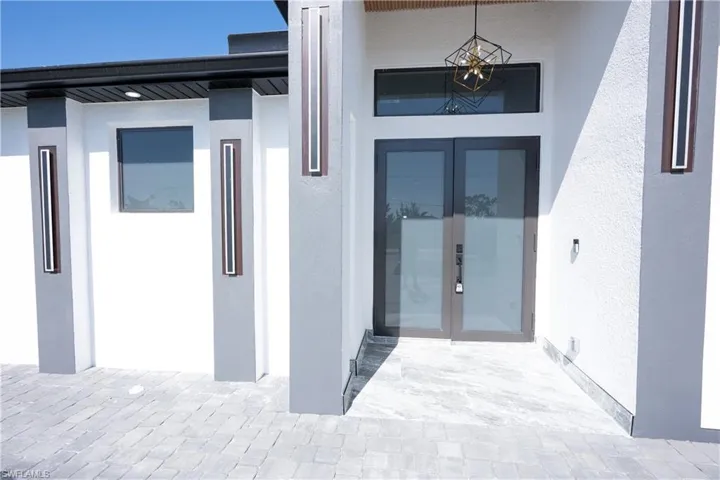 Doorway to property featuring french doors and stucco siding