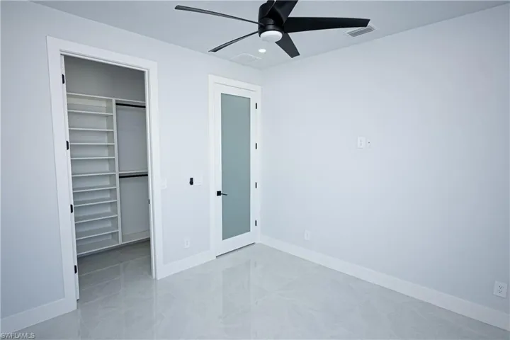 Unfurnished bedroom with a closet, visible vents, recessed lighting, a walk in closet, and baseboards