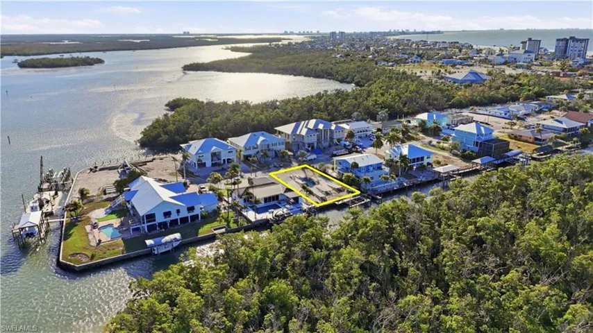Aerial perspective of suburban area with a large body of water and property parcel outlined - Virtually Edited Image