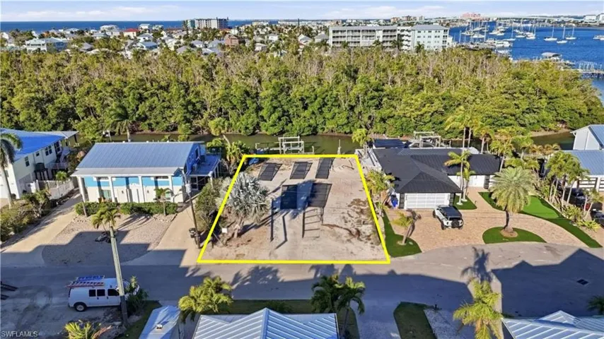 Aerial view of property and surrounding area featuring a large body of water and property boundaries highlighted - Virtually Edited Image