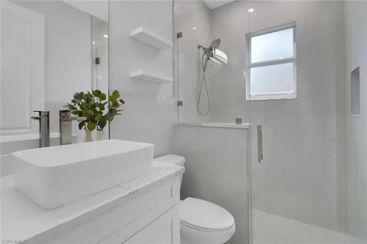 Bathroom with walk in shower, vanity, and toilet