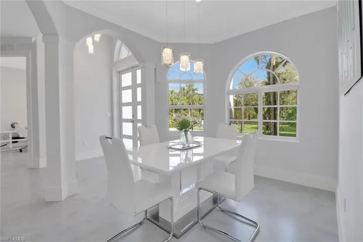 Dining room featuring ornate columns, ornamental molding, and a chandelier