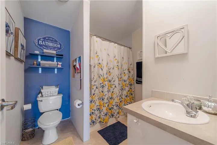 Bathroom featuring vanity, a shower with shower curtain, and tile patterned flooring