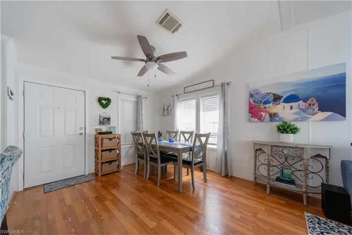 Dining room featuring ornamental molding, light wood finished floors, ceiling fan, and vaulted ceiling