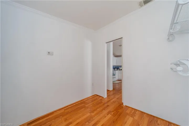 Unfurnished room featuring light wood-style floors and crown molding