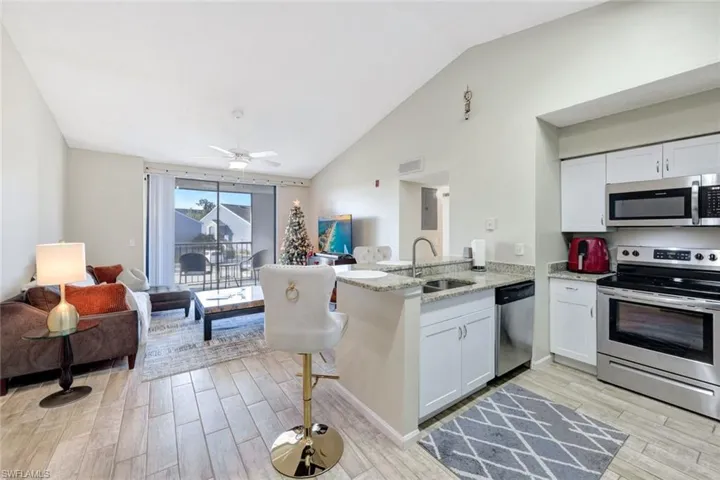 Kitchen featuring white shaker cabinetry, sink, kitchen peninsula, and stainless steel appliances
