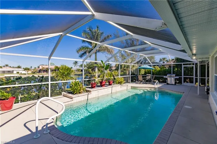 View of pool with a patio, grilling area, and a lanai