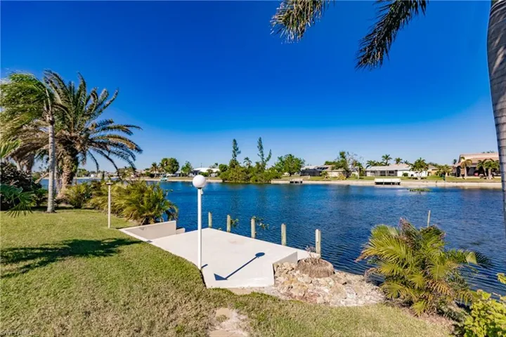 Dock area with a lawn and a water view