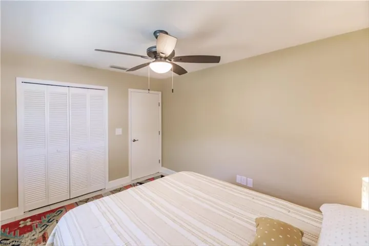 Bedroom with ceiling fan and a closet