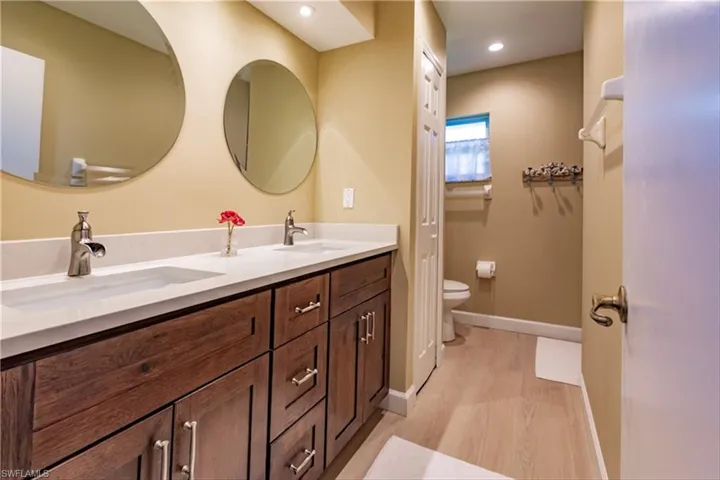 Bathroom with hardwood / wood-style flooring, vanity, and toilet