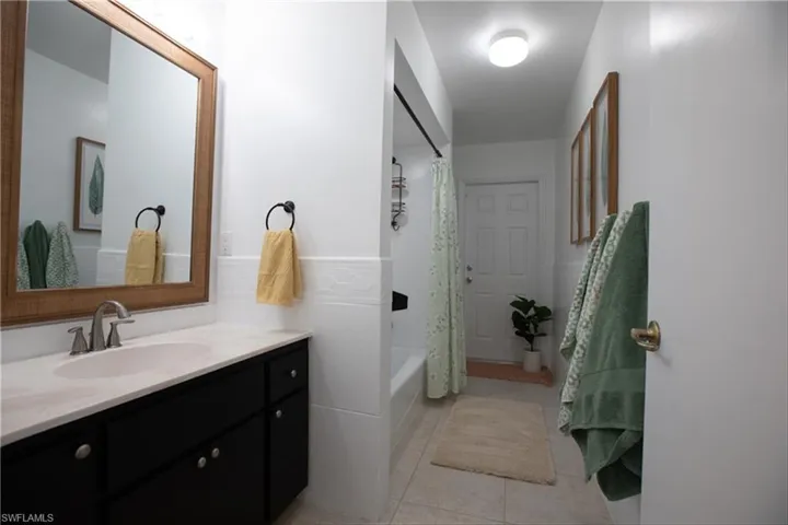 Bathroom featuring shower / bath combo, vanity, and tile patterned floors