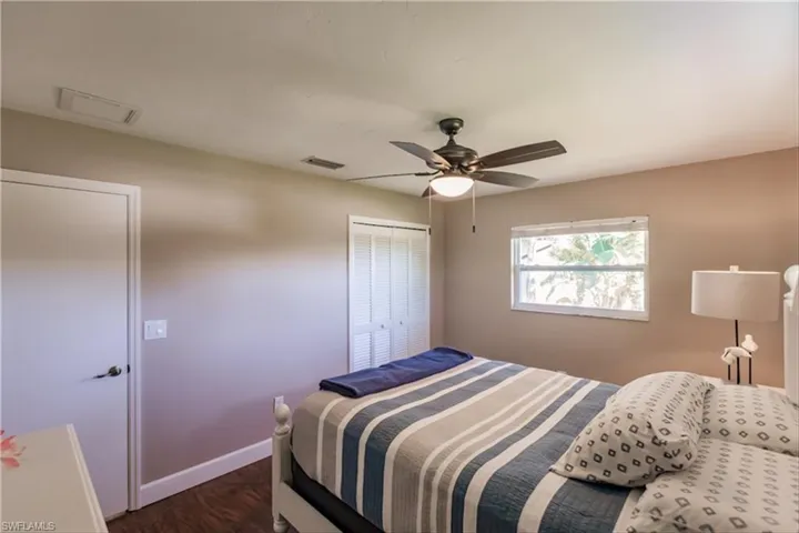 Bedroom featuring ceiling fan, dark hardwood / wood-style floors, and a closet