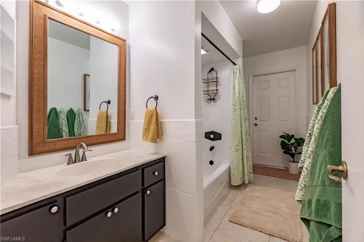 Bathroom featuring tile patterned floors, vanity, and shower / bath combination with curtain