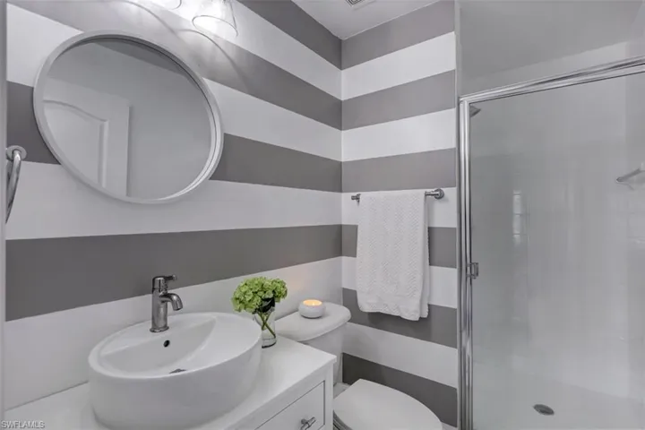 Full bath with vanity, toilet, and a shower stall