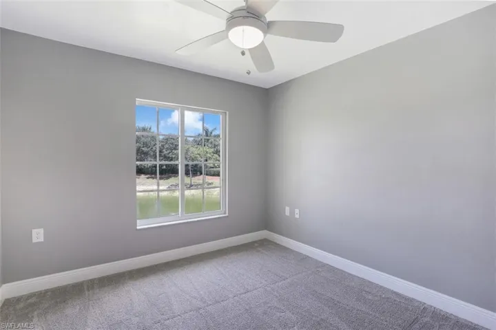 Empty room featuring a ceiling fan, carpet floors, and baseboards