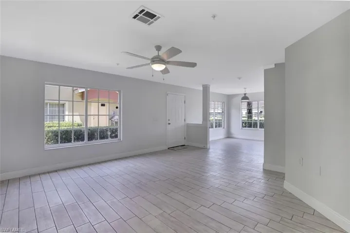 Spare room featuring light wood-type flooring, baseboards, ceiling fan, and visible vents