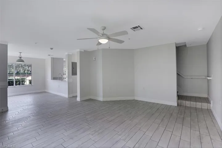 Unfurnished room with light wood-type flooring, visible vents, ceiling fan, and a sink
