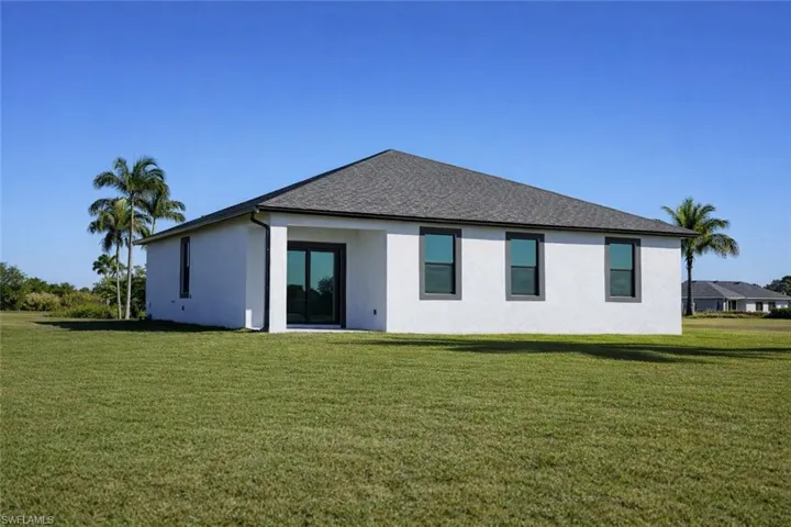 Contemporary single-story residence featuring a white stucco exterior and a dark shingle roof