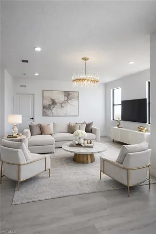Bright living area featuring a modern chandelier, recessed lighting, and wood-finish flooring