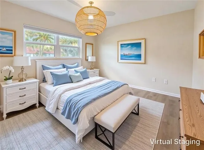 Bedroom featuring neutral wall paint, wood-finish flooring, a woven pendant light fixture, and a white shuttered headboard