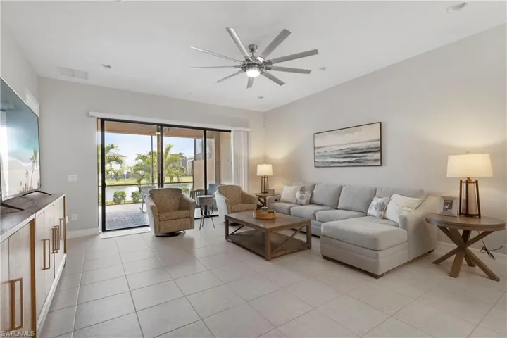 Living room with ceiling fan and light tile patterned flooring