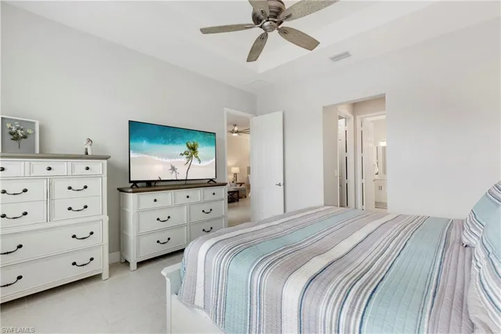 Tiled bedroom with ceiling fan and ensuite bath