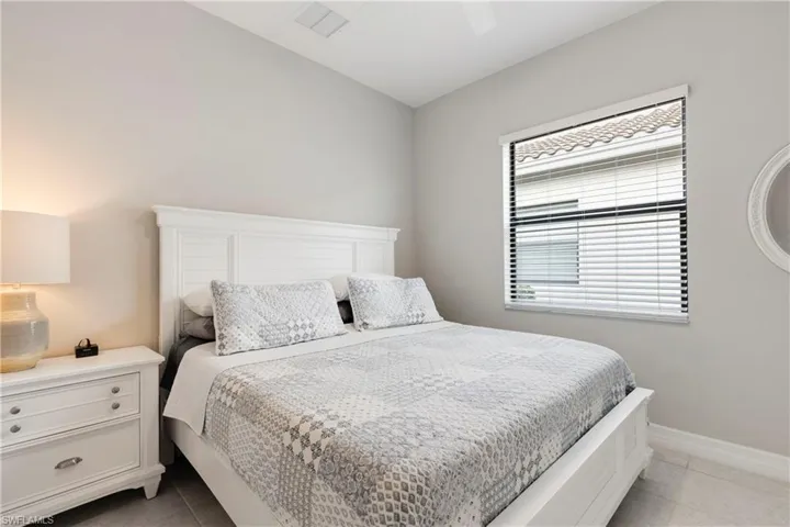 Tiled bedroom featuring ceiling fan