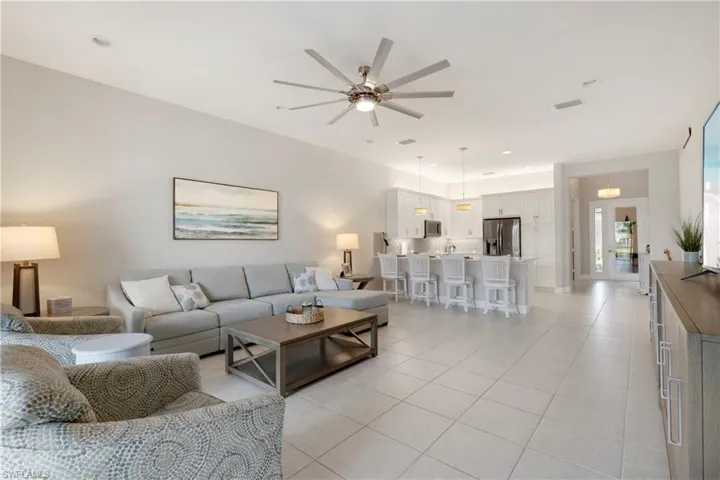 Living room featuring light tile patterned flooring and ceiling fan