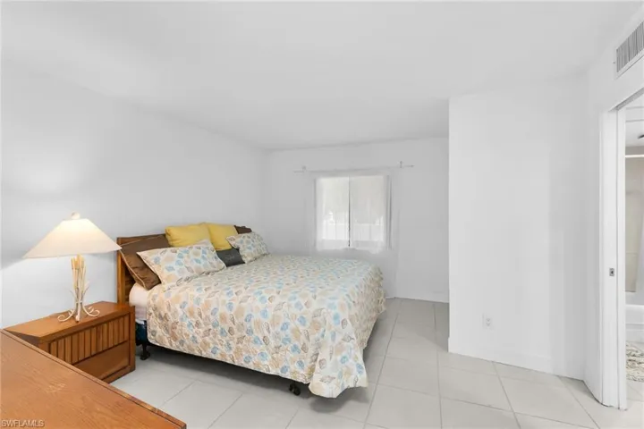 Bedroom featuring light tile patterned floors and baseboards
