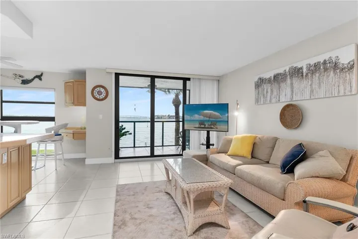 Living room featuring light tile patterned floors, a wall of windows, and an office area