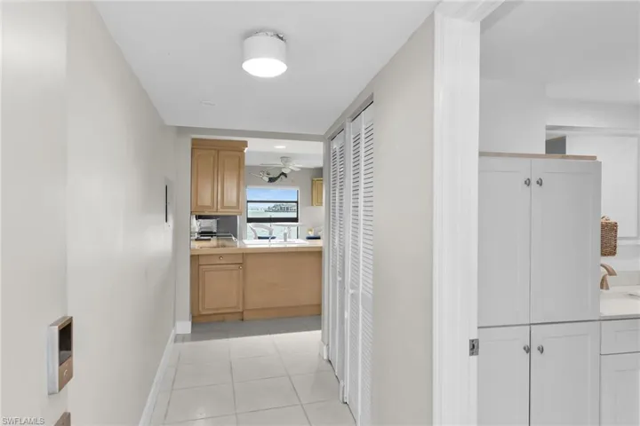 Hall with light tile patterned flooring and baseboards