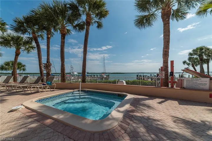 View of pool featuring a community hot tub and a water view