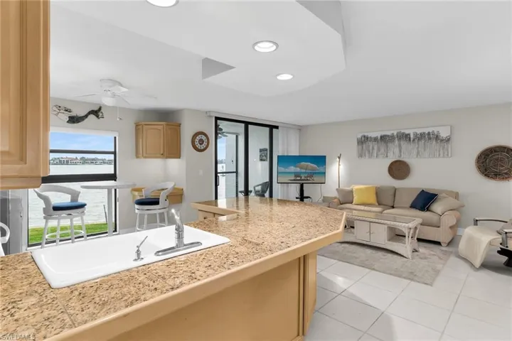 Kitchen with tile counters, recessed lighting, open floor plan, light tile patterned floors, and light brown cabinets